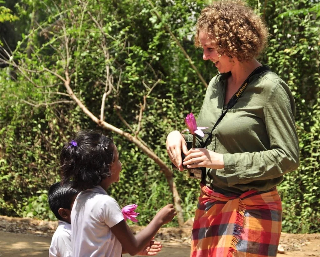 Guest receiving a lotus flower from local Sri Lankan children